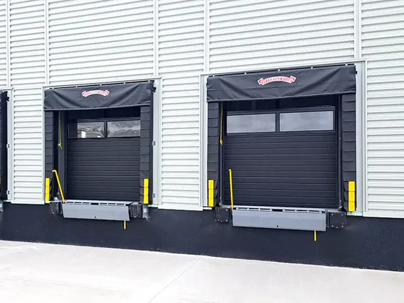 Dock equipment with black canopies and yellow safety bumpers at loading docks, emphasizing reliable solutions for efficient warehouse operations in Lancaster, CA.