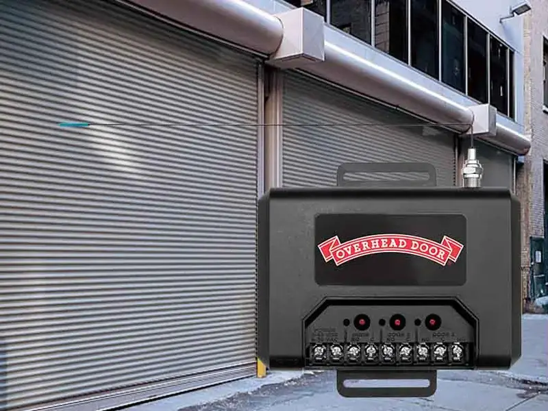 Commercial garage door operator external receiver by Overhead Door, mounted on a wall next to a closed rolling door, enhancing safety and performance for businesses.