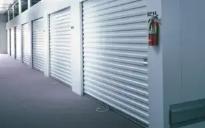 Rolling sheet doors in a commercial setting, showcasing durable and efficient design for various business applications, with visible fire extinguisher for safety compliance.