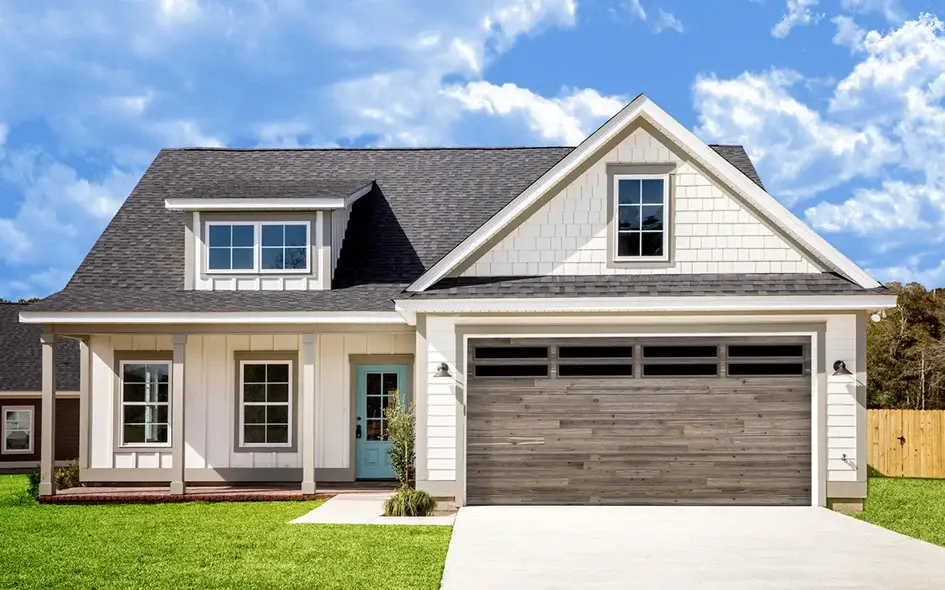 Residential home featuring a modern garage door with wood plank design, showcasing durability and style, surrounded by a well-maintained lawn and blue sky, relevant to Overhead Door Company's offerings.